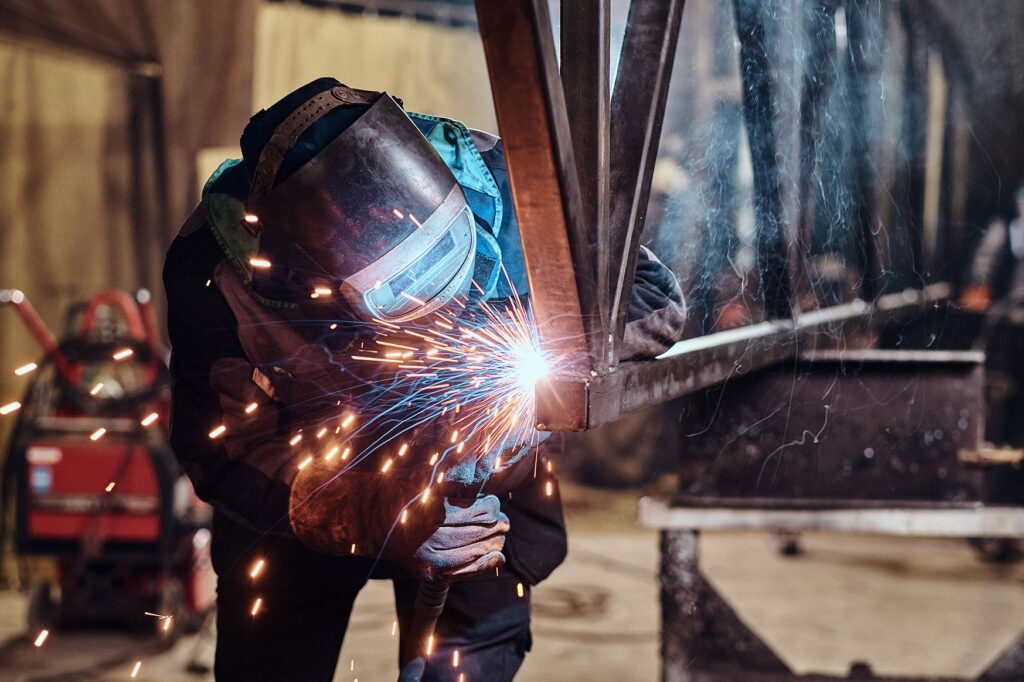 Man is working at the busy metal factory